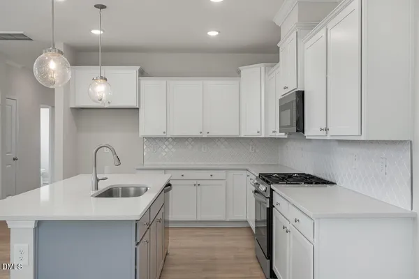 a kitchen with stainless steel appliances a sink a stove and cabinets
