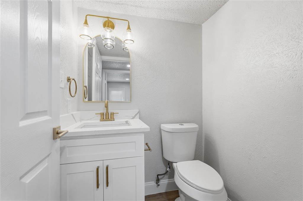 5514 Round Rock Road Garland, TX 75044 - Photo 11 of 37 a bathroom with a toilet a sink and mirror
