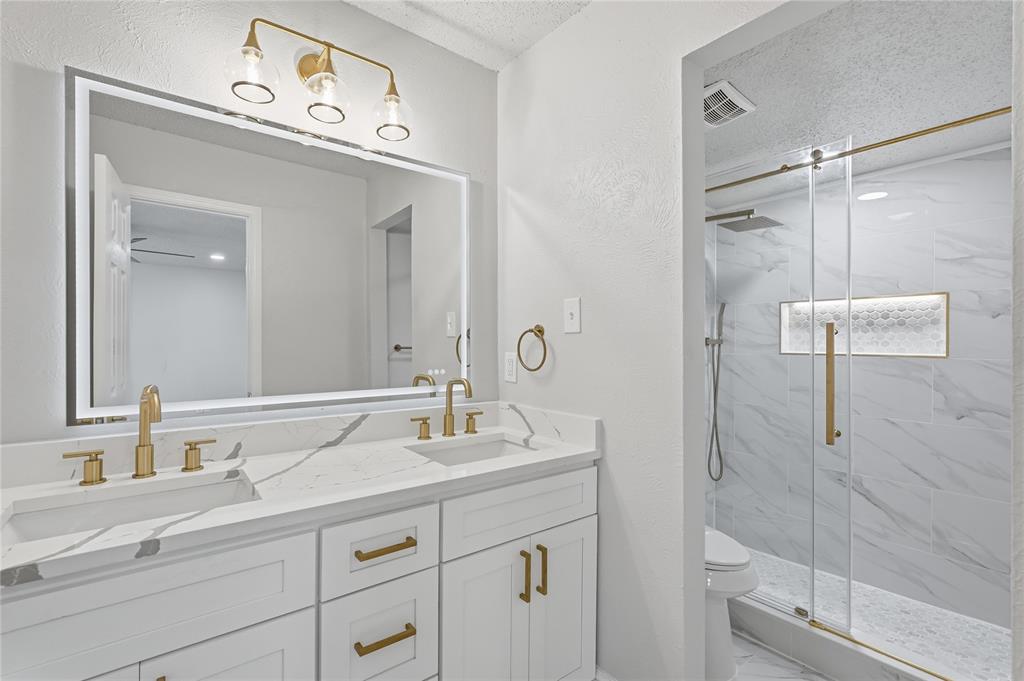 5514 Round Rock Road Garland, TX 75044 - Photo 16 of 37 a bathroom with a double vanity sink mirror and shower