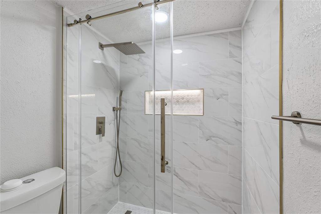 5514 Round Rock Road Garland, TX 75044 - Photo 17 of 37 a bathroom with a shower and toilet