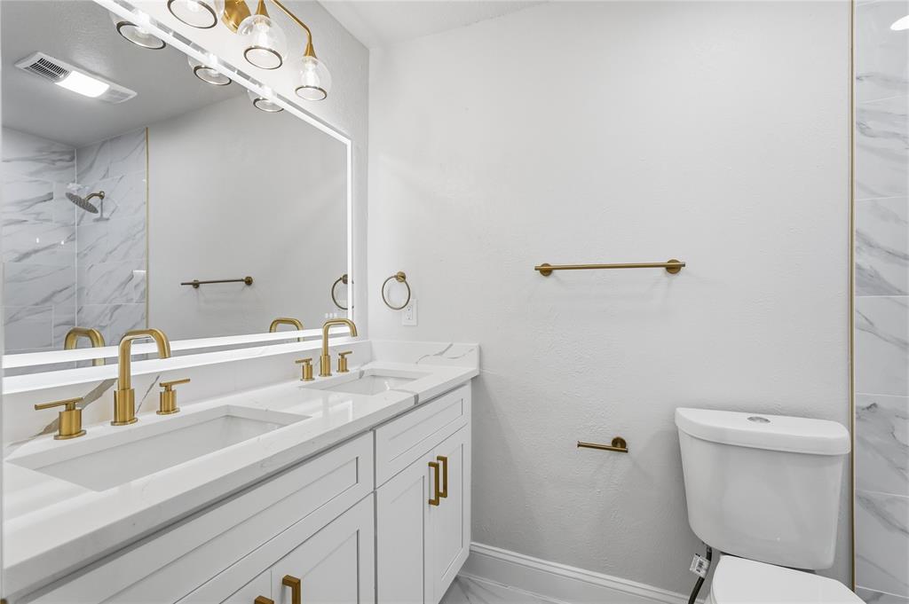 5514 Round Rock Road Garland, TX 75044 - Photo 22 of 37 a bathroom with a sink a toilet and a mirror