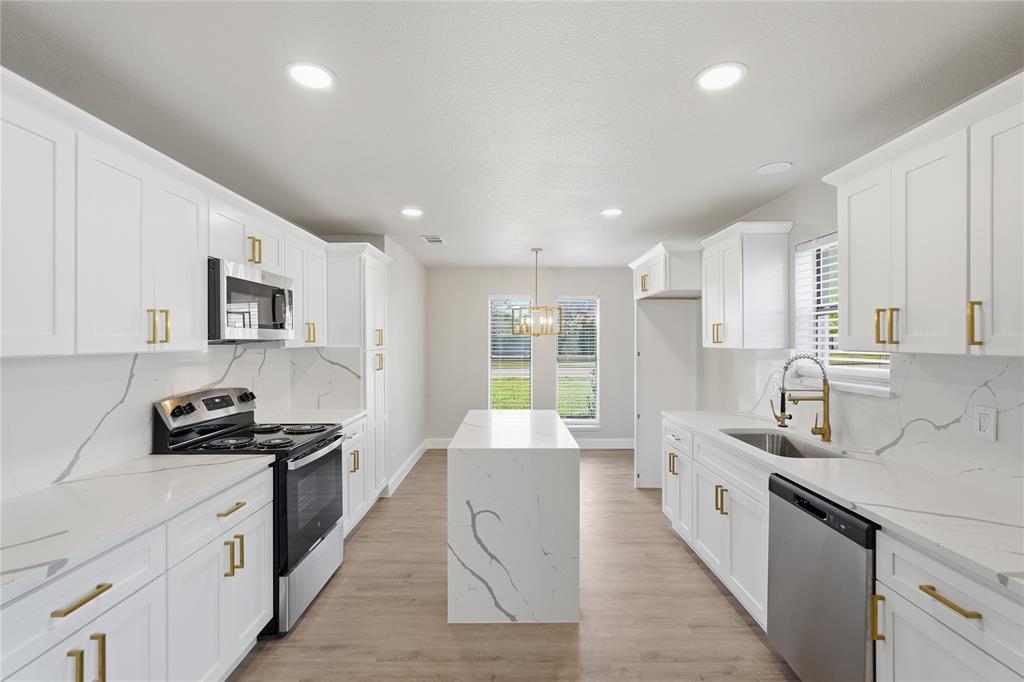 5514 Round Rock Road Garland, TX 75044 - Photo 5 of 37 a large kitchen with stainless steel appliances lots of counter space and wooden floor
