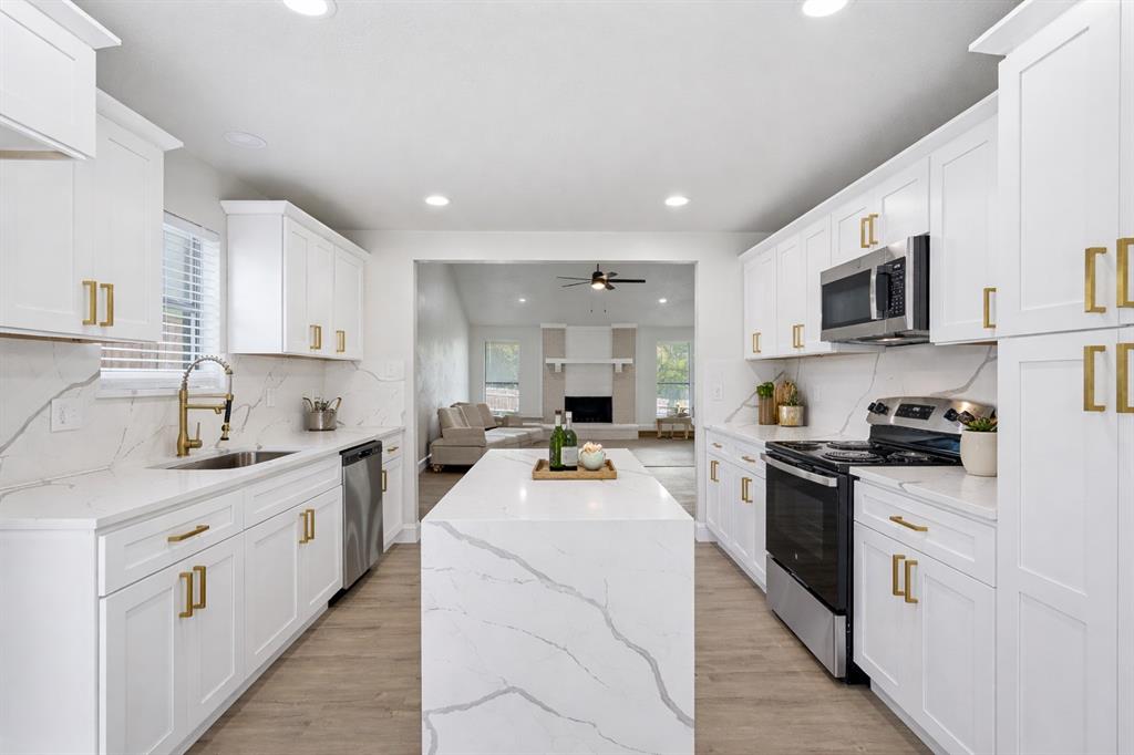 5514 Round Rock Road Garland, TX 75044 - Photo 8 of 37 a kitchen with stainless steel appliances a stove sink microwave and cabinets
