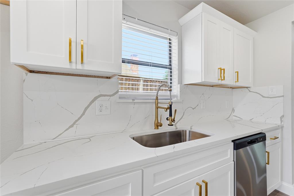 5514 Round Rock Road Garland, TX 75044 - Photo 9 of 37 a kitchen with stainless steel appliances white cabinets a sink and a window