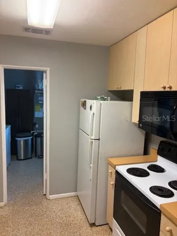 a kitchen with a refrigerator and a stove top oven