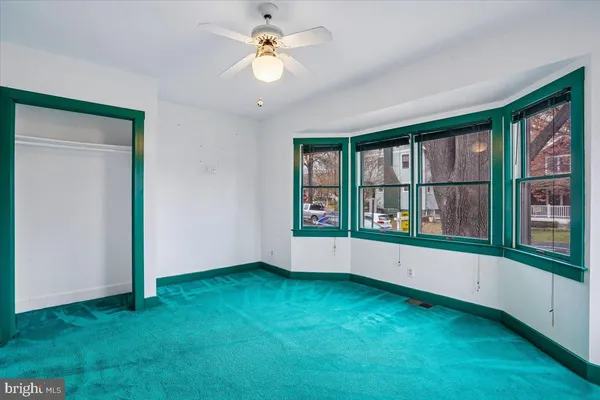 an empty room with windows and closet
