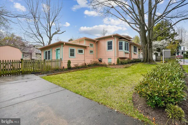 a front view of a house with a yard and trees