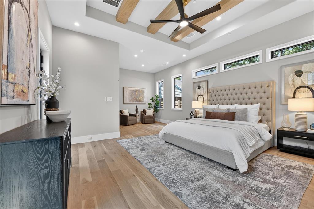11028 Edgemere Road Dallas, TX 75230 - Photo 25 of 40 Expansive room featuring light wood-finish flooring, a tray ceiling with exposed wood beams, and a modern ceiling fan