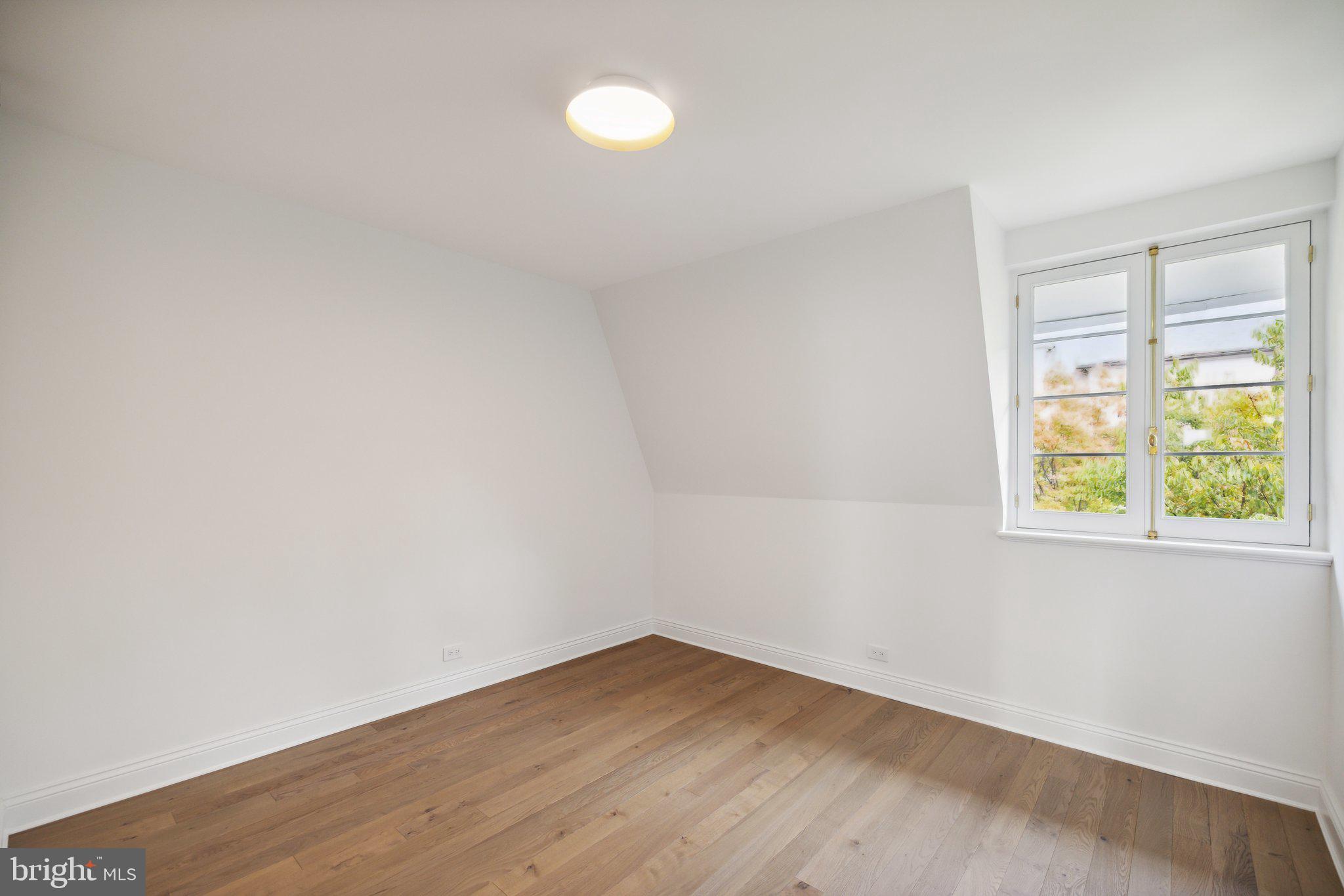 2120 Bancroft Place Northwest Washington, DC 20008 - Photo 21 of 30 a view of an empty room with wooden floor and a window
