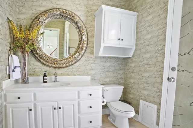 a bathroom with a toilet sink and mirror
