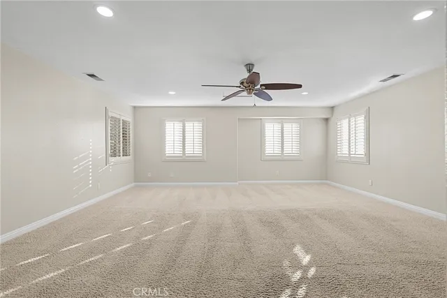 a view of an empty room with a cabinet and a window