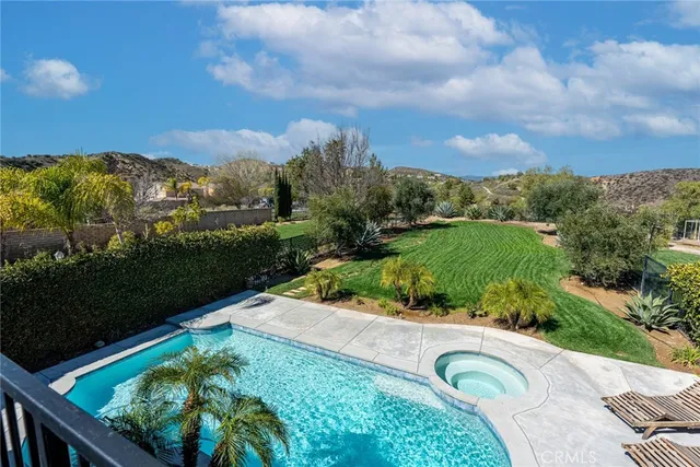 a view of a hallway with wooden floor and chandelier