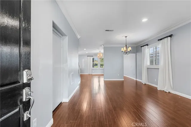 a view of a livingroom with a ceiling fan wooden floor and windows