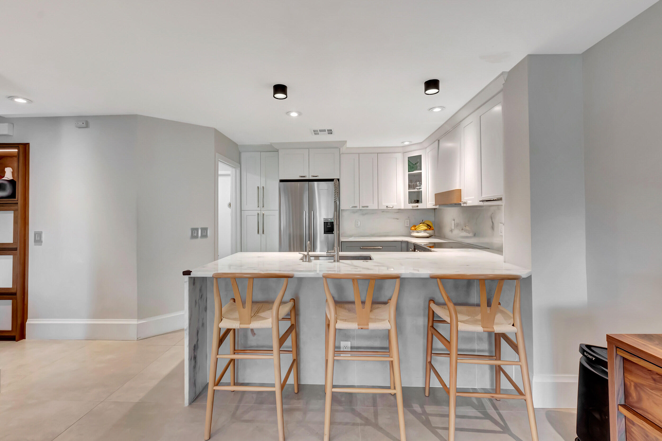 5254 Northwest 22nd Avenue Boca Raton, FL 33496 - Photo 15 of 50 a kitchen with a dining table chairs refrigerator and cabinets