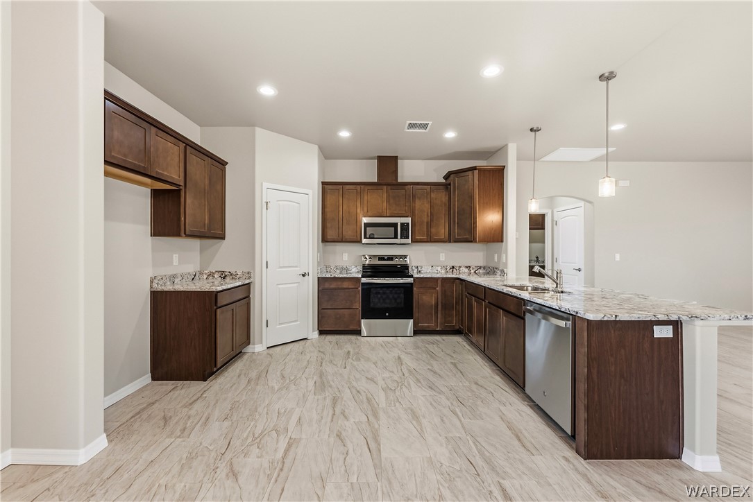 9818 North Cyrus Road Kingman, AZ 86401 - Photo 12 of 42 a large kitchen with stainless steel appliances kitchen island granite countertop a large counter top stainless steel appliances and cabinets