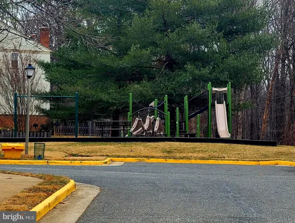 a view of swimming pool with lawn chairs and large trees