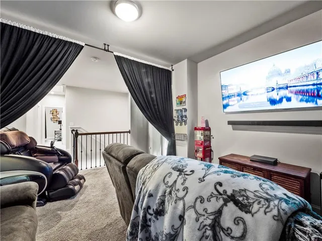 a bedroom with a bed and a flat tv screen on dresser