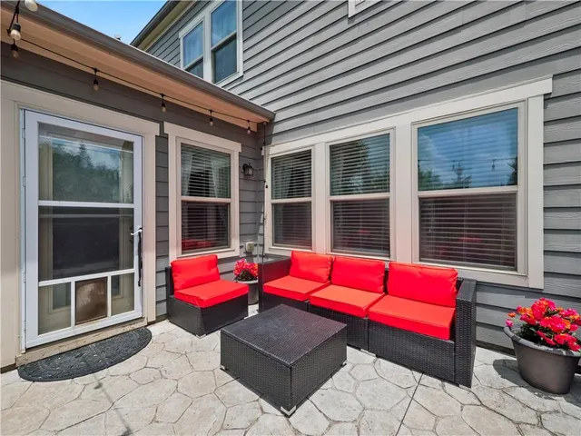 a balcony with table and chairs and potted plants