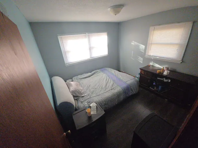 a bed sitting in a bedroom next to a window