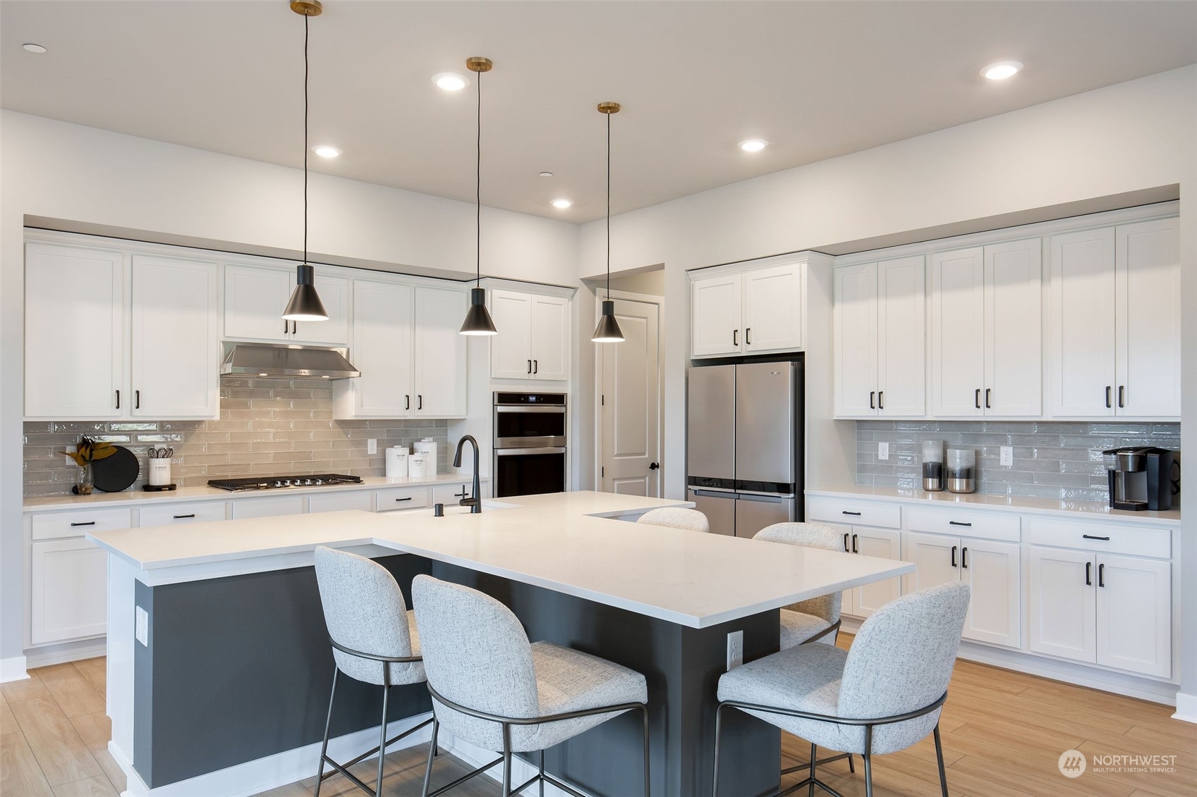 3900 Northeast 27th Place, Unit 3 Renton, WA 98059 - Photo 8 of 37 a kitchen with stainless steel appliances kitchen island a table chairs and a refrigerator