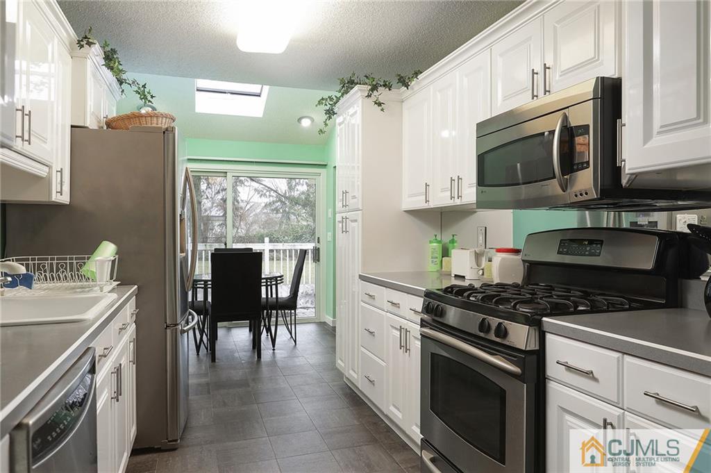 2 Rumson Road Kendall Park, NJ 08824 - Photo 12 of 28 a kitchen with stainless steel appliances a stove a sink and a refrigerator