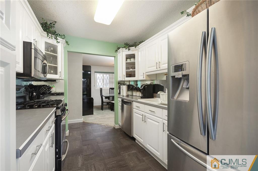 2 Rumson Road Kendall Park, NJ 08824 - Photo 13 of 28 a kitchen with stainless steel appliances a refrigerator sink stove microwave and cabinets
