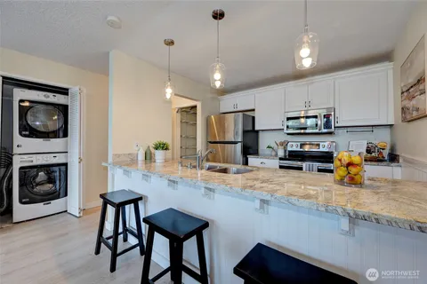 a kitchen with stainless steel appliances granite countertop a stove refrigerator sink and microwave