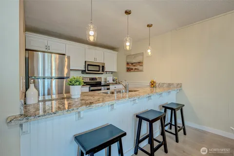 a kitchen with stainless steel appliances granite countertop a sink refrigerator and microwave