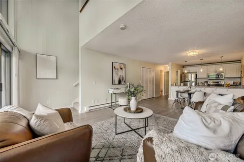 a living room with furniture and view of kitchen