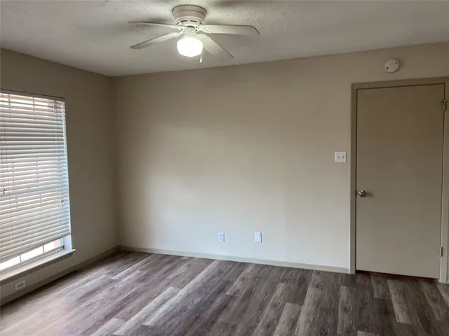 an empty room with wooden floor and closet