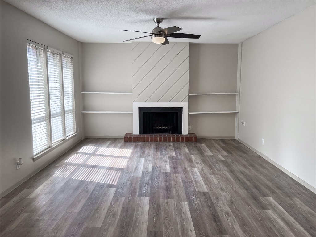 7206 Creekside Drive, Unit C Austin, TX 78752 - Photo 5 of 22 an empty room with windows and a fireplace