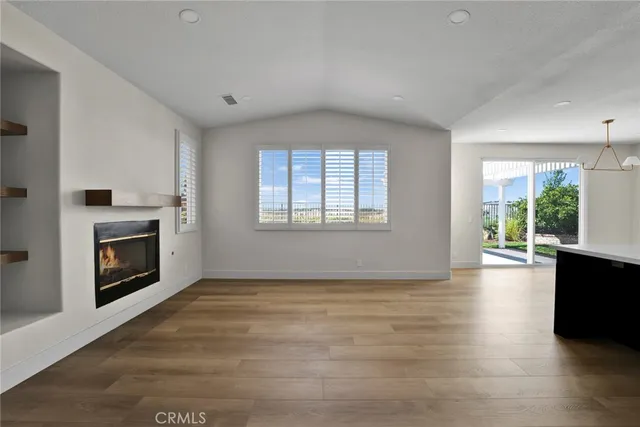 a view of empty room with a fireplace and wooden floor