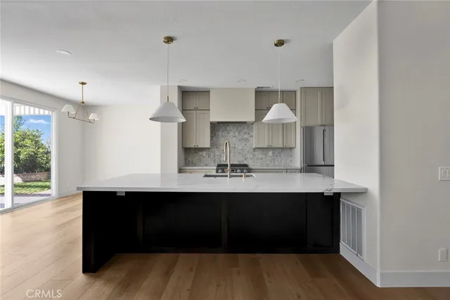 a kitchen with stainless steel appliances a sink cabinets and wooden floor