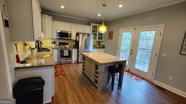 a kitchen with stainless steel appliances granite countertop a refrigerator a stove top oven a sink dishwasher and wooden floor