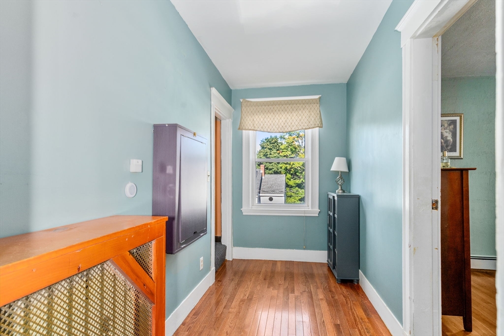 87 Waldeck Road Milton, MA 02186 - Photo 16 of 21 a view of hallway with a large window and wooden floor