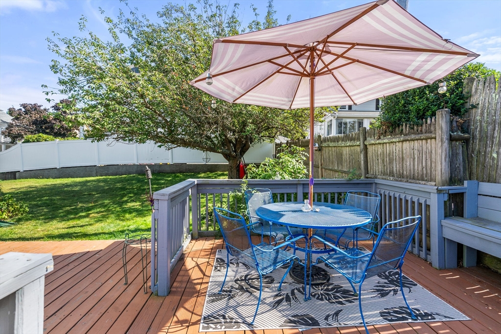 87 Waldeck Road Milton, MA 02186 - Photo 19 of 21 a patio with wooden floor a yard a table and chairs