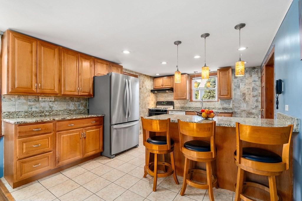 87 Waldeck Road Milton, MA 02186 - Photo 7 of 21 a kitchen with granite countertop cabinets and stainless steel appliances