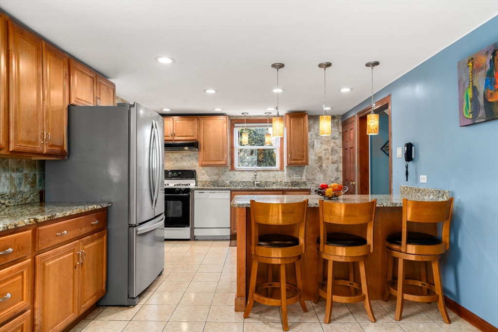 87 Waldeck Road Milton, MA 02186 - Photo 9 of 21 a large kitchen with a table and chairs
