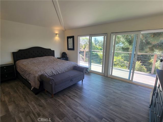 a spacious bedroom with a bed and wooden floor
