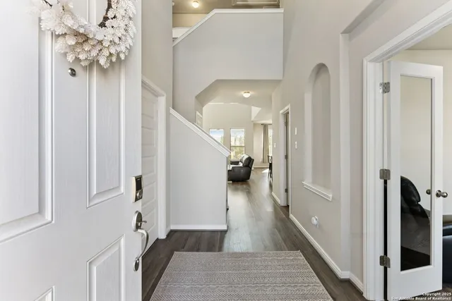 a view of a hallway with wooden floor and staircase