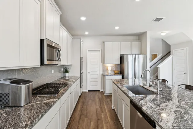 a kitchen with stainless steel appliances granite countertop a sink stove and refrigerator