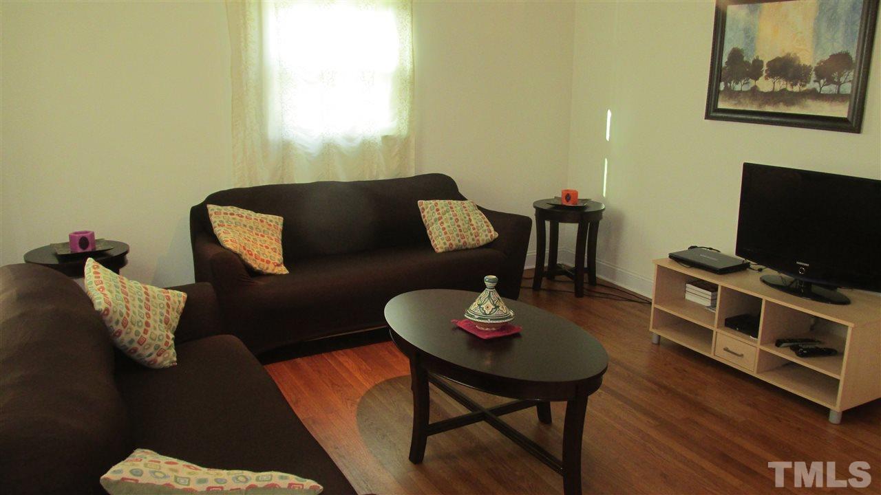 4823 Revere Road Durham, NC 27713 - Photo 3 of 15 a living room with furniture and a flat screen tv