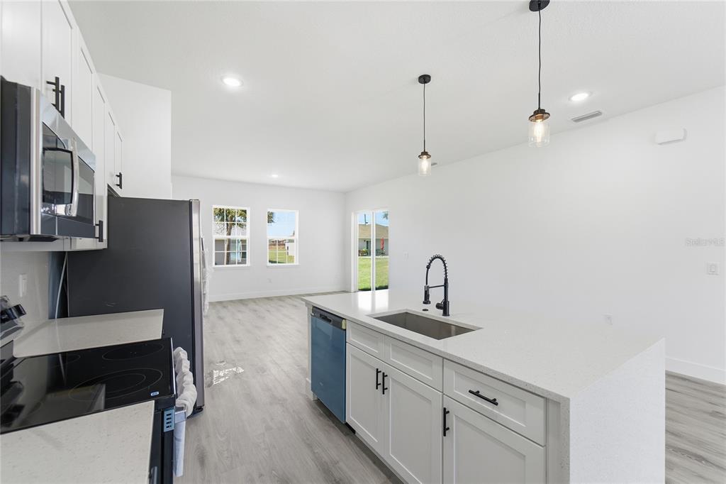 2600 Southwest 146th Pl Road Ocala, FL 34473 - Photo 40 of 40 a kitchen with stainless steel appliances granite countertop a sink stove and refrigerator