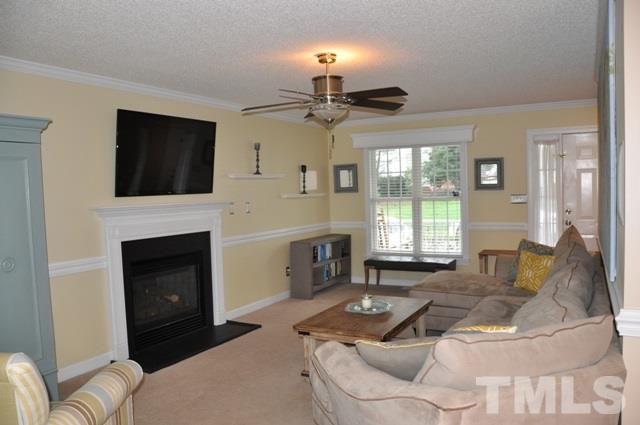 8512 Powis Circle Raleigh, NC 27615 - Photo 3 of 25 a living room with furniture a fireplace and a flat screen tv