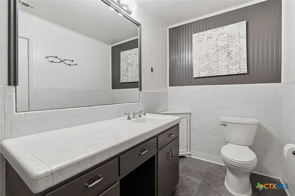 a bathroom with a toilet a sink and mirror