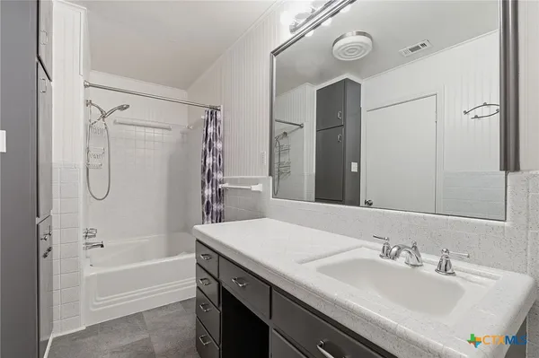 a bathroom with a tub sink and mirror