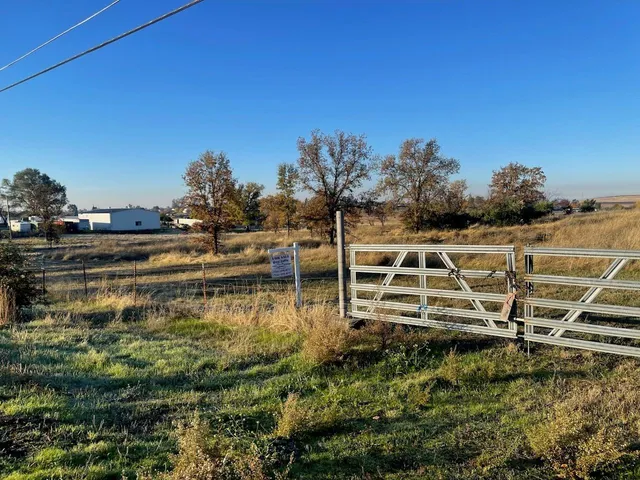 a view of a yard with wooden fence