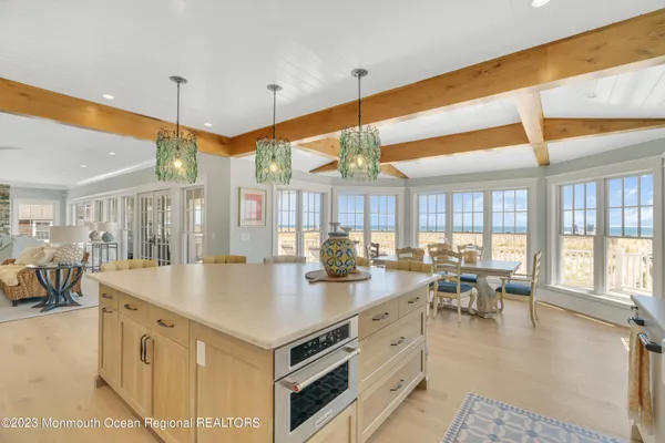 a kitchen with stainless steel appliances granite countertop a sink a counter space and living room view