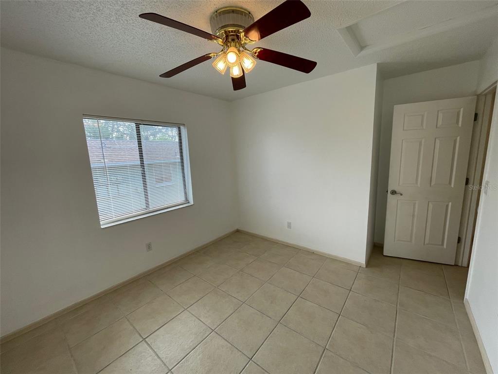 9000 Griggs Road, Unit C Englewood, FL 34224 - Photo 11 of 14 an empty room with chandelier fan