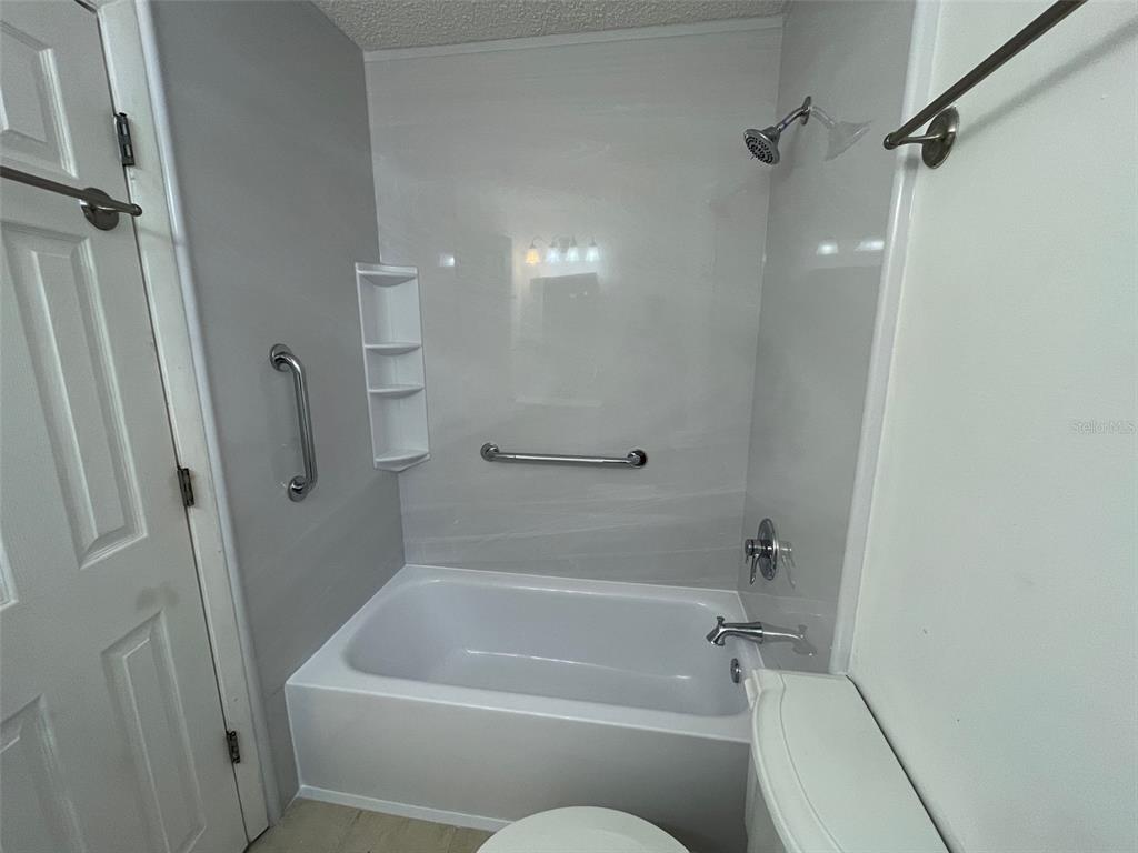 9000 Griggs Road, Unit C Englewood, FL 34224 - Photo 13 of 14 a bathroom with a tub and a shower